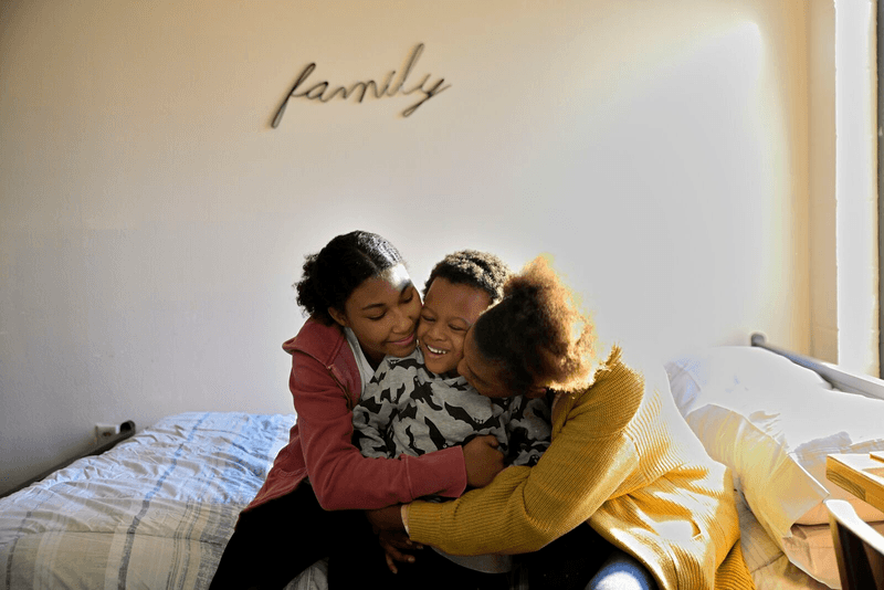 Three family members hugging each other.